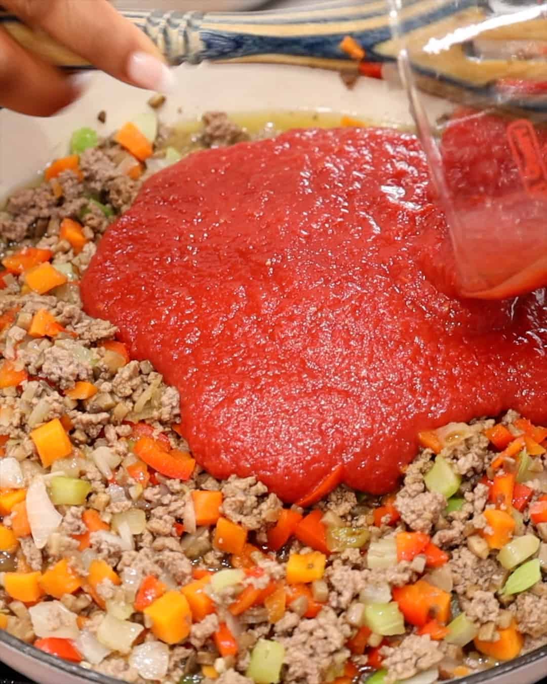 ADDING CRUSHED TOMATOES TO MIXTURE