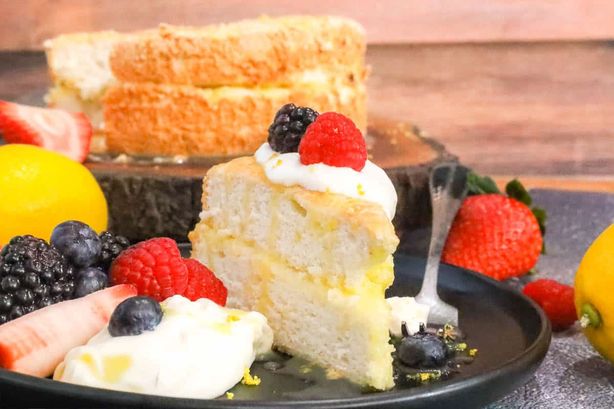 Angel Food Cake Recipe on black plate with fruits
