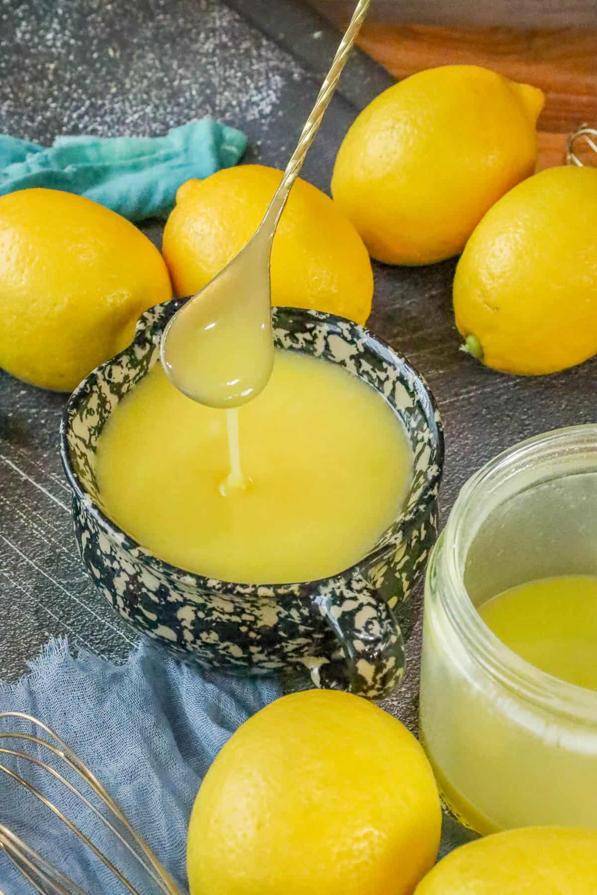 lemon sauce and lemons on board and being lifted with spoon