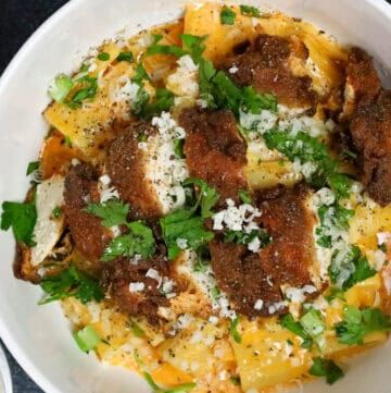 gochujang pasta topped with chicken breast and topped with fresh herbs