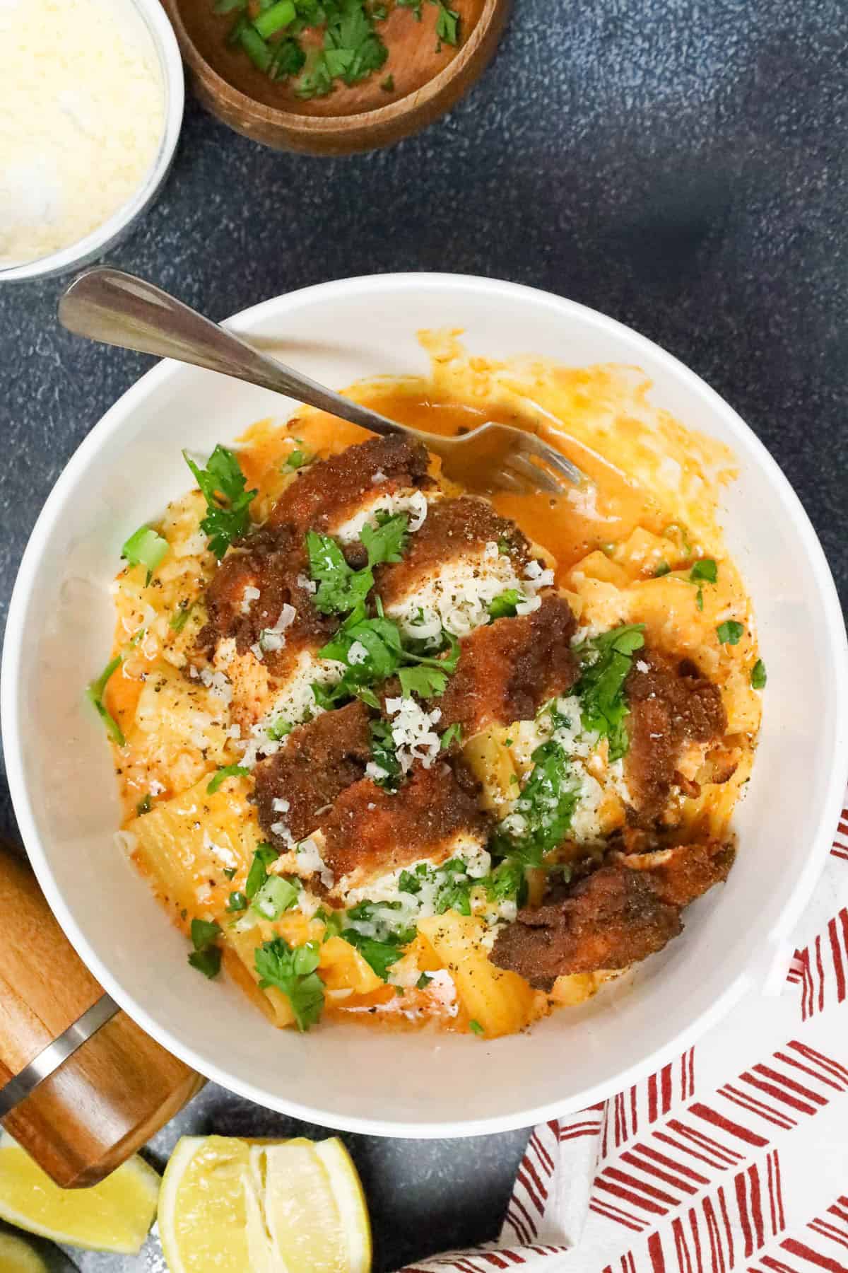 gochujang pasta topped with chicken breast and topped with fresh herbs