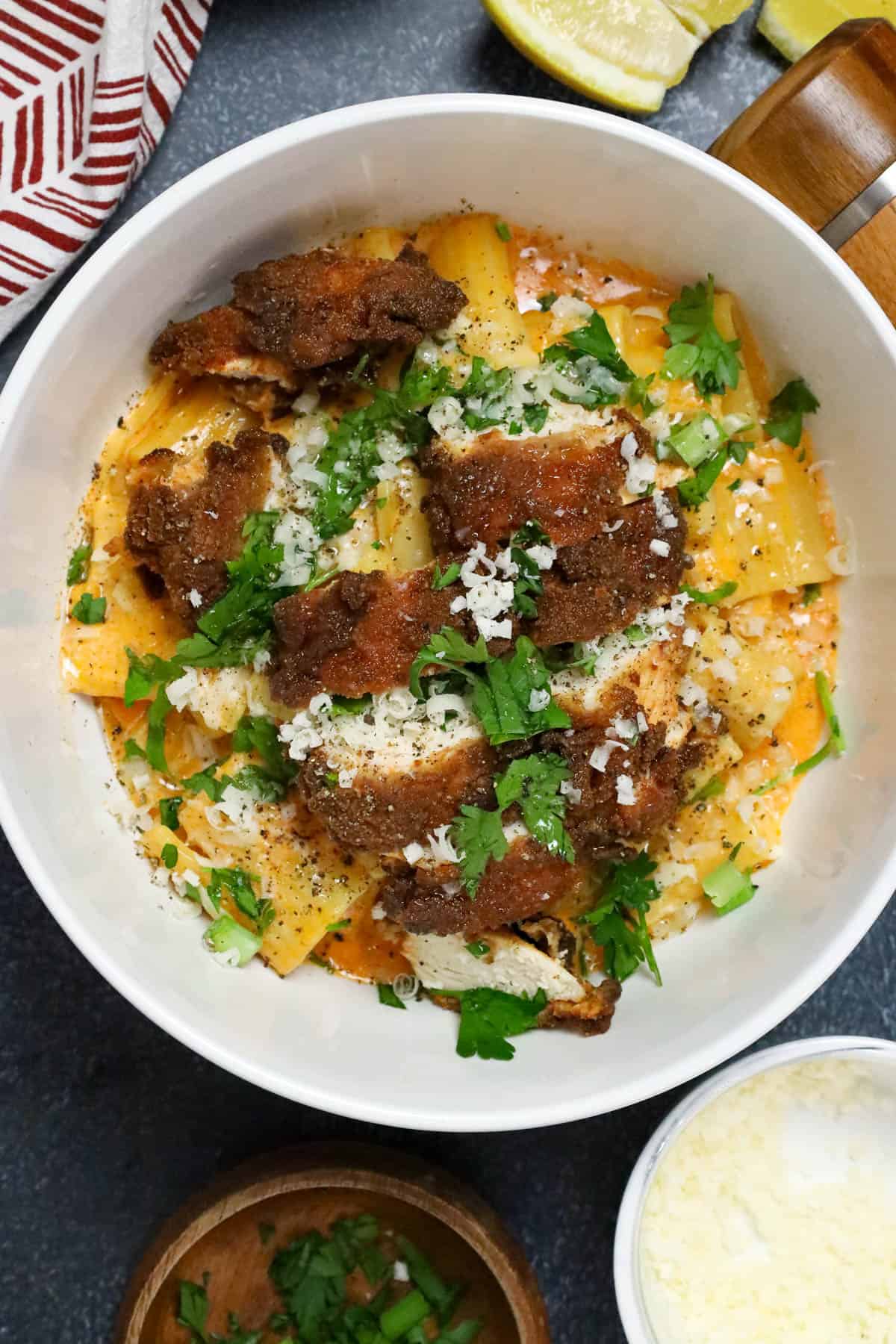 gochujang pasta topped with chicken breast and topped with fresh herbs