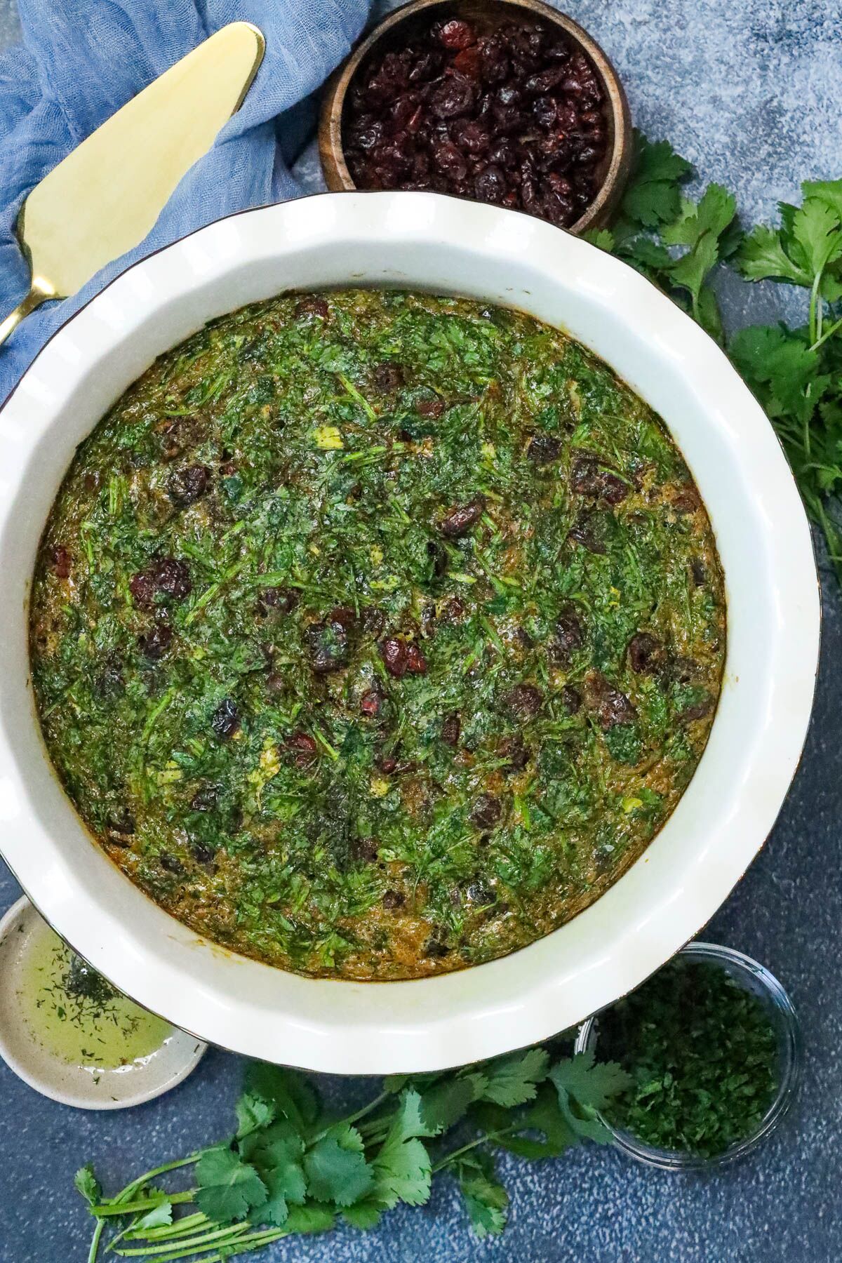 Easy Kuku Sabzi Recipe (Persian Herb Frittata) on board with raisins
